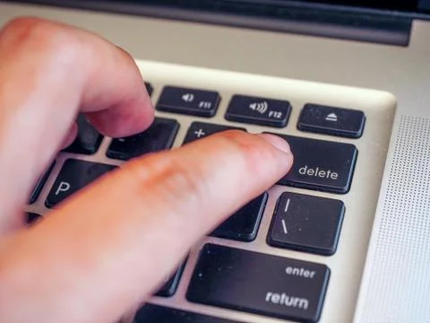 Finger pushing delete button on a keyboard of computer Foto stock