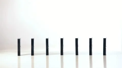 Finger pushing dominoes in a row causing a chain reaction Video stock 11499399