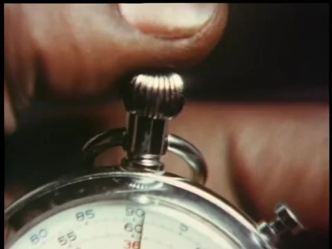 Finger pushing down the start button on a stop watch Stock Footage 260240364