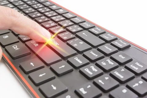 Finger pushing enter button on black keyboard,light effect Stock Photos