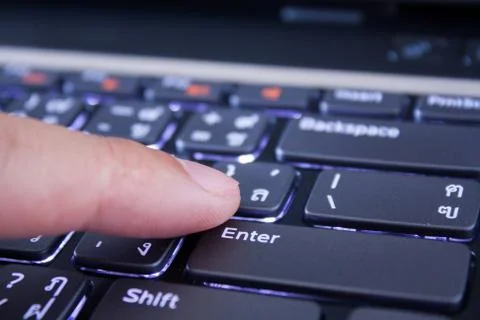 A finger is pushing the enter button Stock Photos