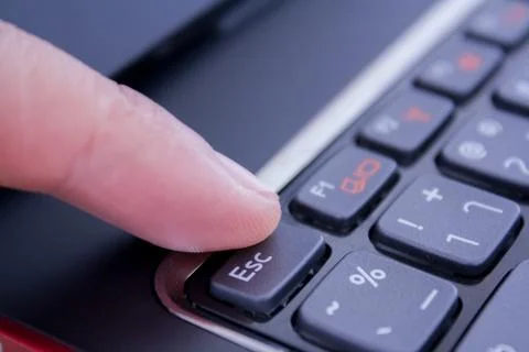 A finger is pushing the escape button Stock Photos