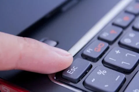 A finger is pushing the escape button Stock Photos