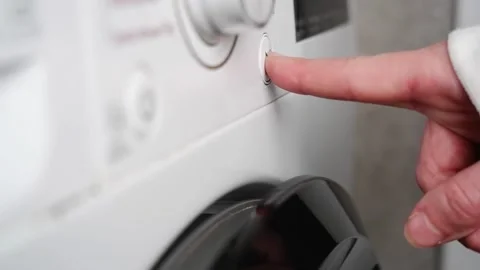 Finger pushing power button on washing machine Stock Footage 304364854