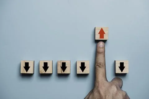 Finger pushing red up arrow which it opposite direction from black down arr.. Stock Photos