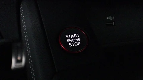 Finger pushing start engine button very dark close up. The button is backlit. Stock Footage 92659445