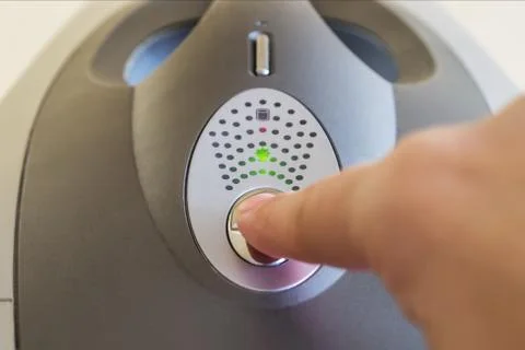 Finger is ready to push on Off button on the top of the personal computer. Stock Photos