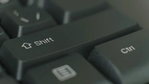 Finger repeatedly pressing the shift key on a black keyboard. Stock Footage 145684220