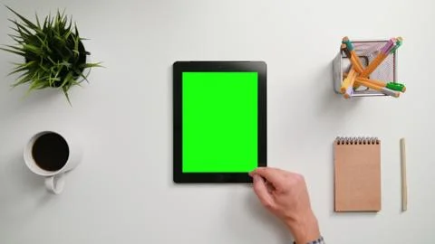 A Finger Scrolling on the Green Touchscreen Stock Photos
