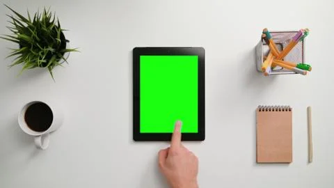 A Finger Scrolling on the Green Touchscreen Stock Photos