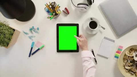 A Finger Scrolling on the Green Touchscreen Stock Photos