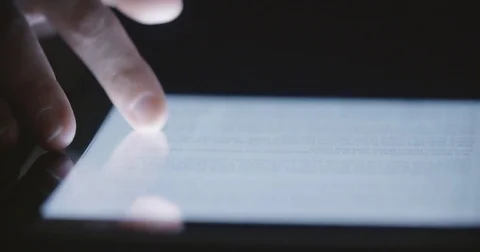 Finger Scrolls on Tablet Dark Toward Camera Stock Footage 84874494