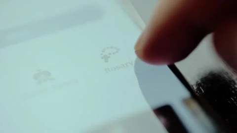 Finger selecting the Rosary devotion on smartphone screen Video stock 326943219