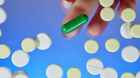 Finger selects pills on a flat transparent surface Stock Footage 261185632