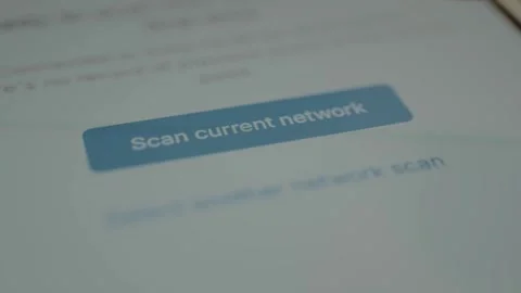 Finger selects the on screen button labeled Scan current network, search for Stock Footage 328344738