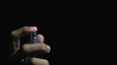 Finger spraying perfume on black background. Stock Footage 294699702