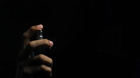 Finger spraying perfume on black background. Stock Footage 294699714