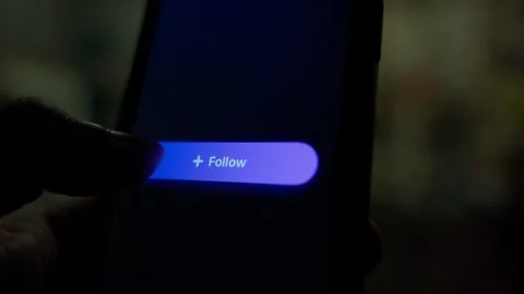 Finger tapping follow button on smartphone screen and switching to following Stock Footage 342811271