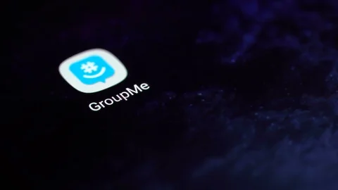 Finger tapping the GroupMe icon to open the application on a smartphone. Stock Footage 107167703