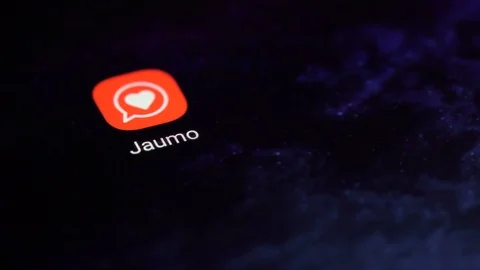 Finger tapping the Jaumo icon to open the application on a smartphone. Stock Footage 107167678
