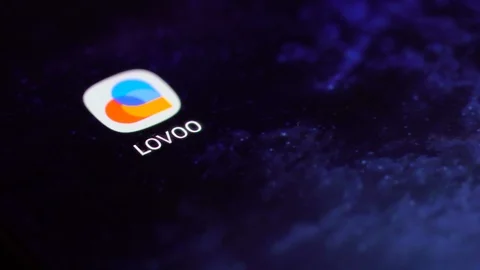 Finger tapping the Lovoo icon to open the application on a smartphone. Stock Footage 107168005