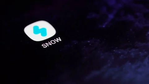 Finger tapping the Snow icon to open the application on a smartphone. Stock Footage 107168238