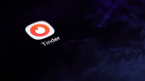 Finger tapping the Tinder icon to open the application on a smartphone. 動画素材 107168735