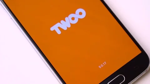 Finger tapping the Twoo icon to open the application on a smartphone. Stock Footage 106930569