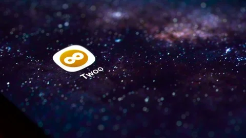 Finger tapping the Twoo icon to open the application on a smartphone. Stock Footage 107168799