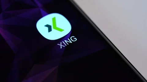 Finger tapping the Xing icon to open the application on a smartphone. Stock Footage 108563916