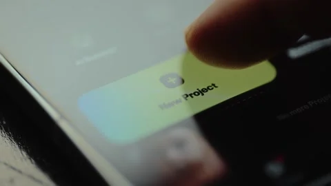 Finger taps the New Project digital button within a design creating app Stock Footage 327523614