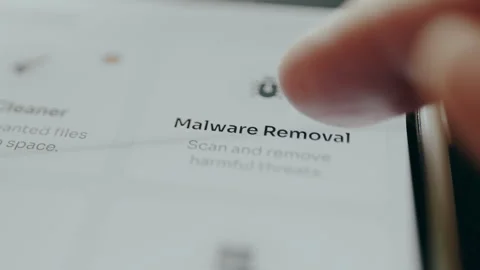 Finger taps the option labeled Malware Removal for removing harmful threats Stock Footage 329282615