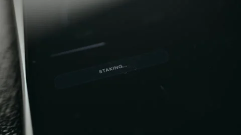 Finger taps the option labeled STAKE 32 ETH, status STAKING Stock Footage 332062821
