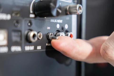 A finger toggles a phono line selector switch on the back panel of professional Stock Photos