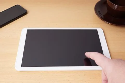 Finger touching blank touchscreen on tablet computer Stock Photos