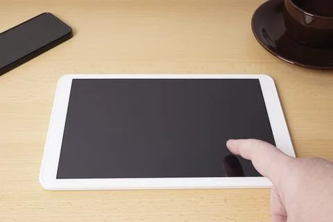 Finger touching blank touchscreen of tablet computer from personal perspective Stock Photos