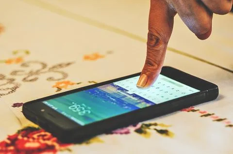Finger touching the screen of a smartphone Stock Photos