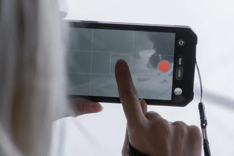 Finger touching smartphone screen to focus camera app Stock Photos