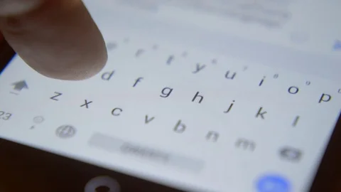 Finger touching virtual keys form a digital keyboard of a touchscreen phone Stock Footage 71294572