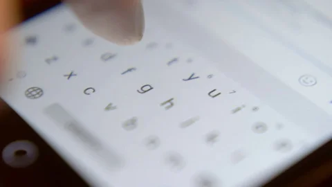 Finger touching virtual keys form a digital keyboard of a touchscreen phone Video stock 71294599