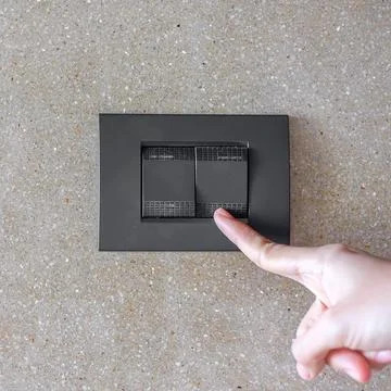 Finger turn on or off on light switch on wall at home. Energy Saving, power.. Stock Photos