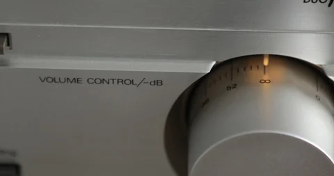 Finger is turning down the volume in a stereo, switch with decibel indicators. Stock Footage 108013932