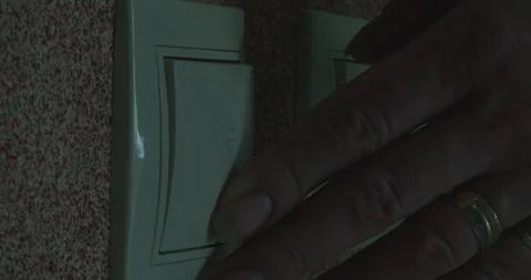 Finger turning on light switch in a dark room Stock Footage 305642370