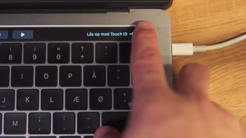 Finger unlocking a MacBook Pro via the biometric fingerprint scanner. Stock Footage 153186647