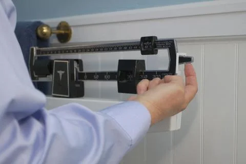 Finger on weight scale Stock Photos