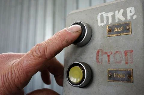 Finger of worker pushing button Open on a control panel Stock Photos