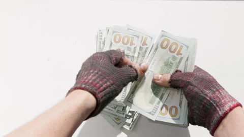 Fingerless gloves hands counting large stack of money on white table Stock Footage 345996170