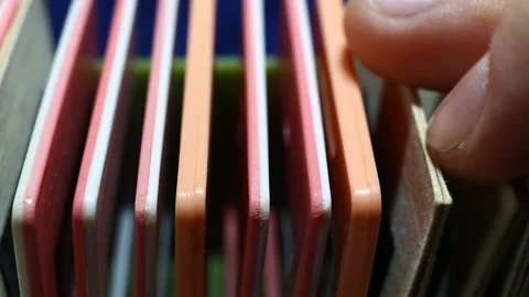 Fingers are sorting through colored plastic and paper frames standing in a row o Stock Footage 149220549