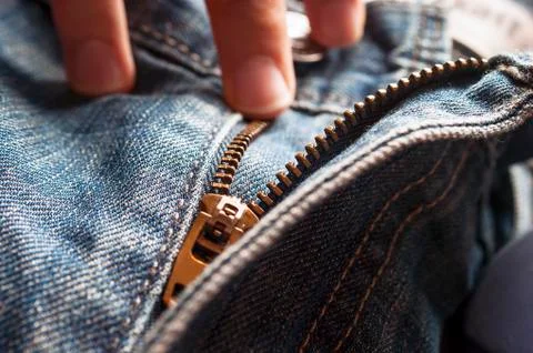 Fingers on Button and Elements of Denim Blue Jeans Metal Zipper. Stock Photos