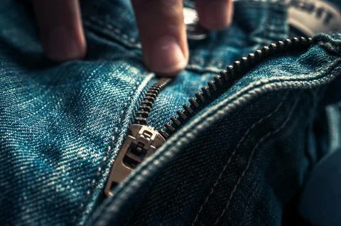 Fingers on Button and Elements of Denim Blue Jeans Metal Zipper. Stock Photos
